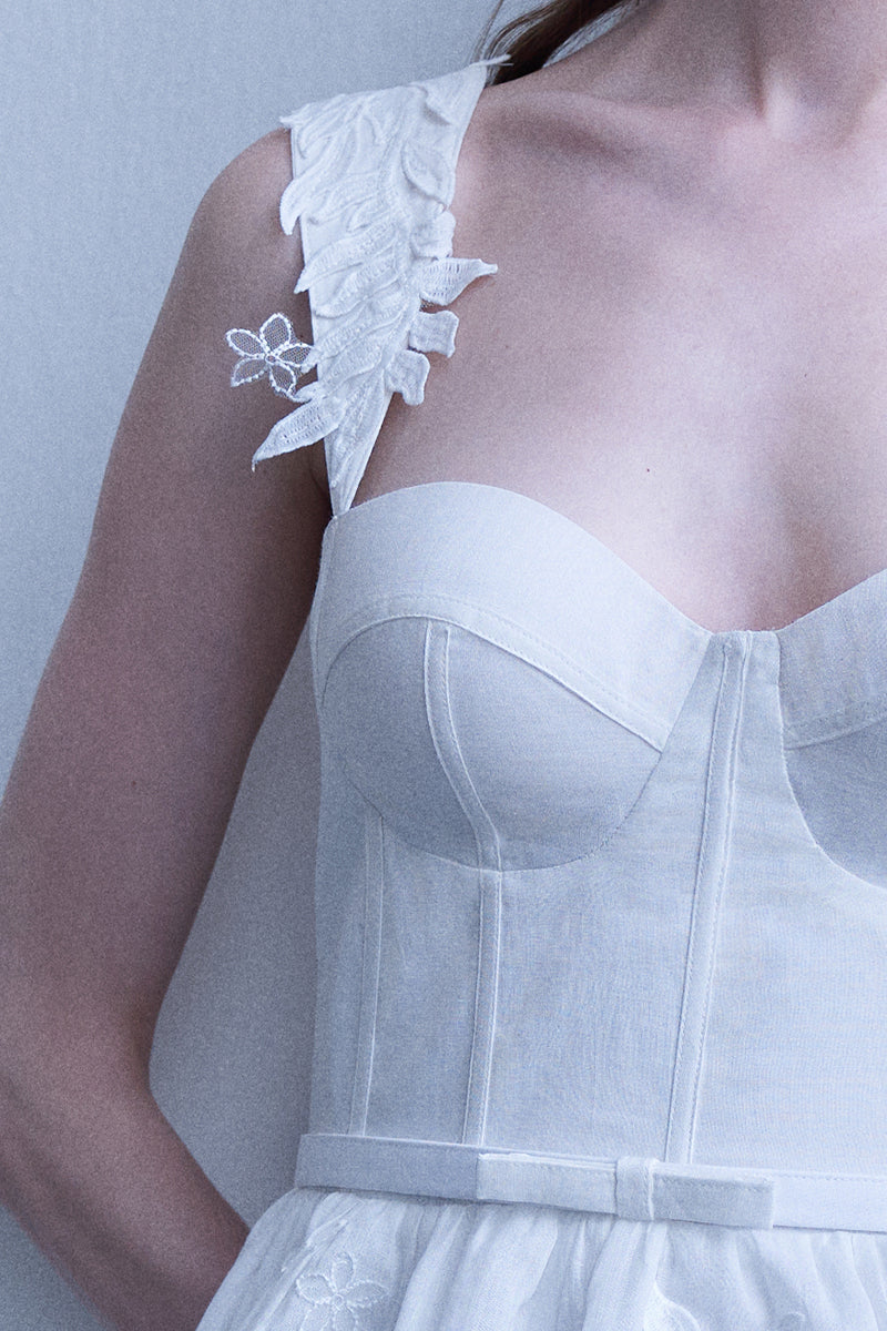 AISA Emma white mini dress displayed on a hanger, showcasing its fitted silhouette and simple, elegant design.