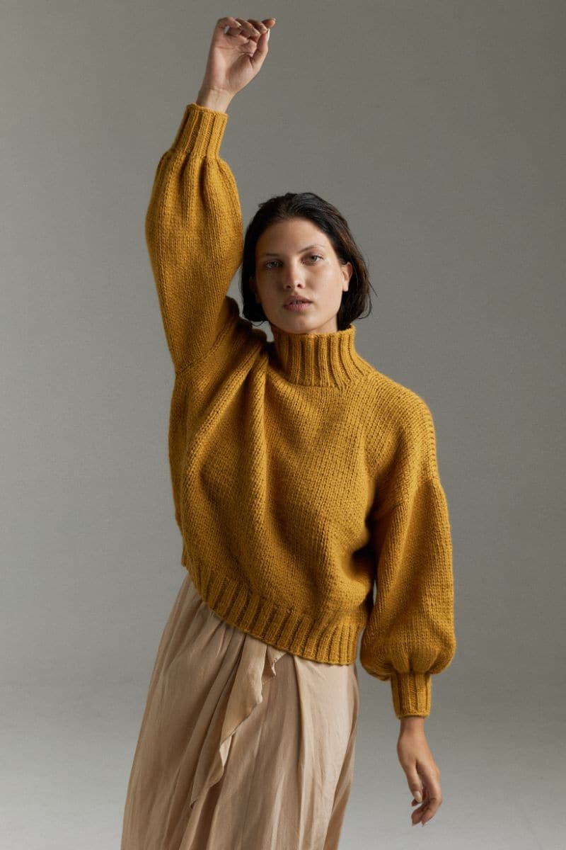 Mustard Eve midi turtleneck sweater by First Born Knits, showing a cozy, fitted sweater in mustard yellow with ribbed details.