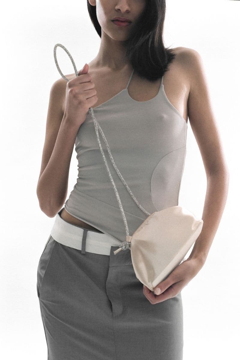Gold mini money pouch clutch by Folklore The Label with a sleek compact design and zip closure.