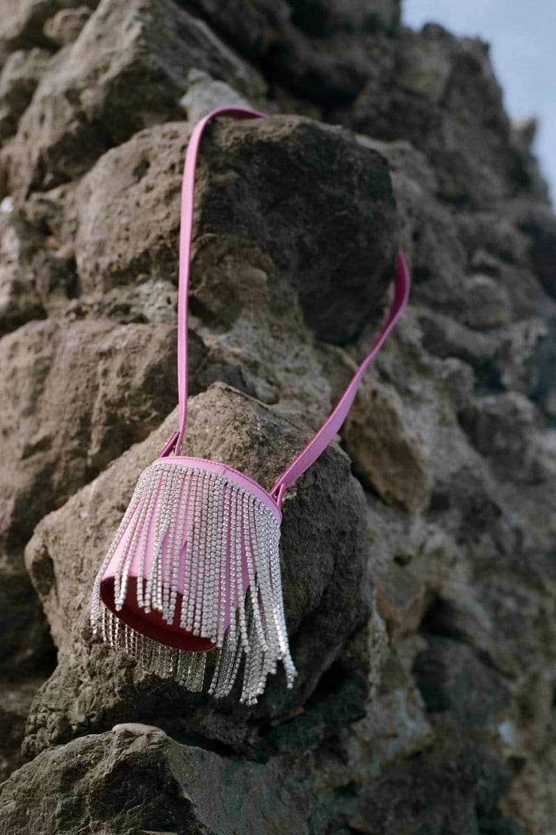 Pink fringe mini Kyklos bag from Folklore The Label, a stylish top handle bag with vibrant fringe details and compact design.