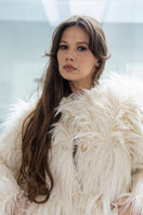 Cream faux fur jacket by Fortini, stylish and warm, shown on a model with a plush collar and cozy fit.