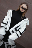 White sporty faux fur jacket by Fortini, featuring a stylish design with black accents, shown on a model.