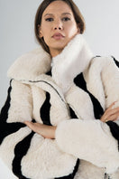 White sporty faux fur jacket by Fortini, featuring a sleek design with black accents, displayed on a hanger.