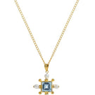 Gold Blue Topaz Cross Necklace by Freya Rose featuring a vibrant blue topaz pendant on a delicate chain