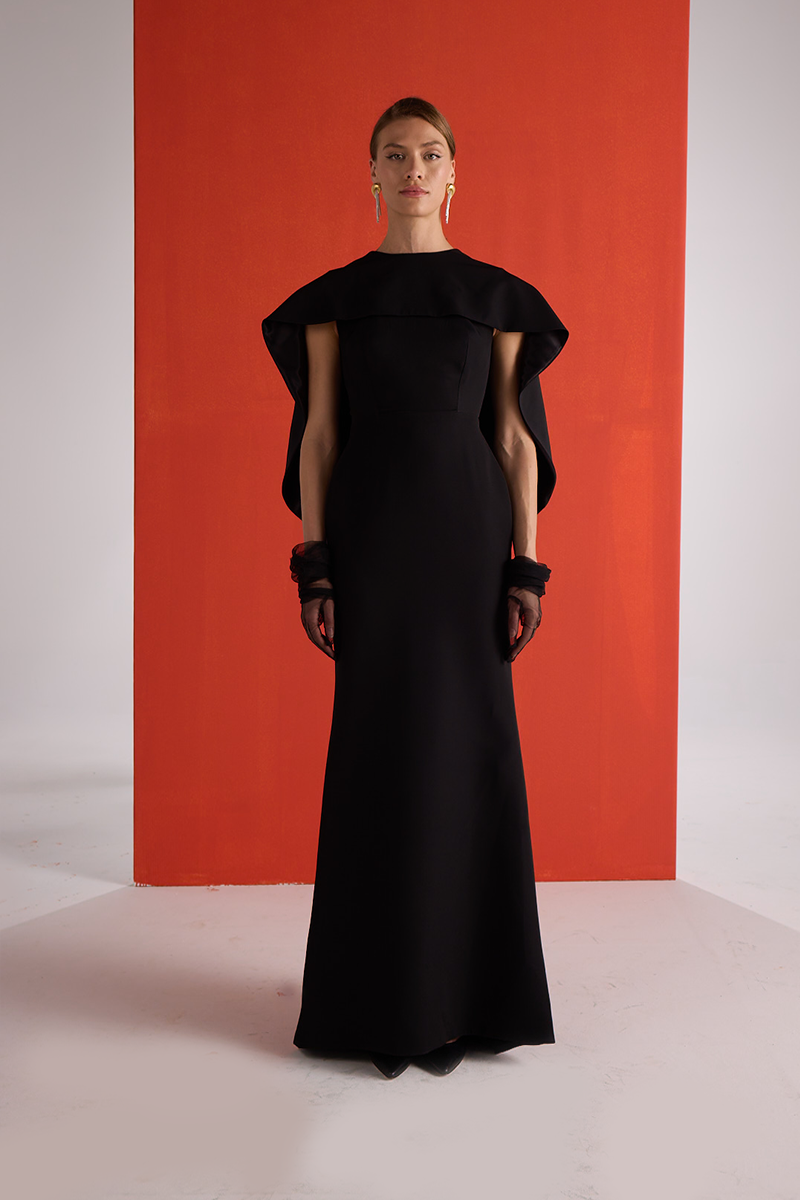 Joanna Andraos black cascade gown showing a flowing, elegant front view with layered fabric and intricate design details.