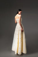 Light yellow CULT MIA X HAPPY CLOTHING strapless gown in stone organza with a flowing design and elegant texture.
