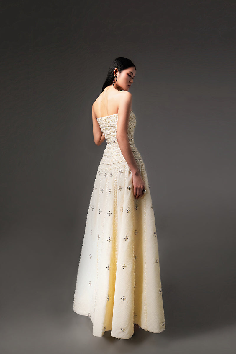 Light yellow CULT MIA X HAPPY CLOTHING strapless gown in stone organza with a flowing design and elegant texture.