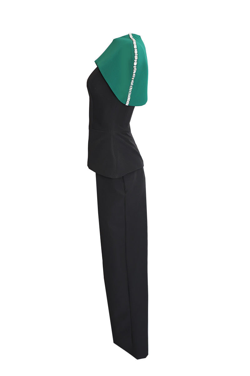 Joanna Andraos black co-ords set with top and pants, featuring a detachable emerald cape, shown from the side.