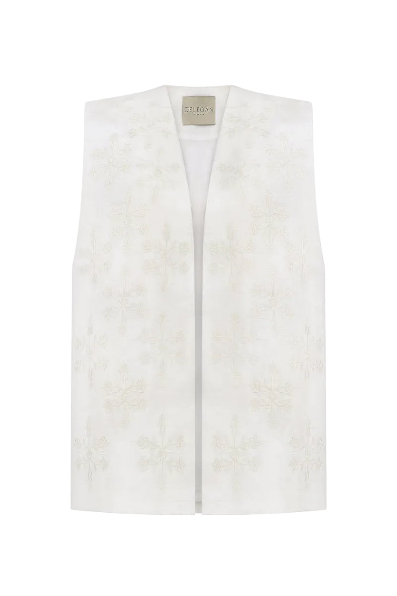 White milk-embroidered vest by Delegan displayed on a ghost mannequin, showcasing the front design and embroidery details.