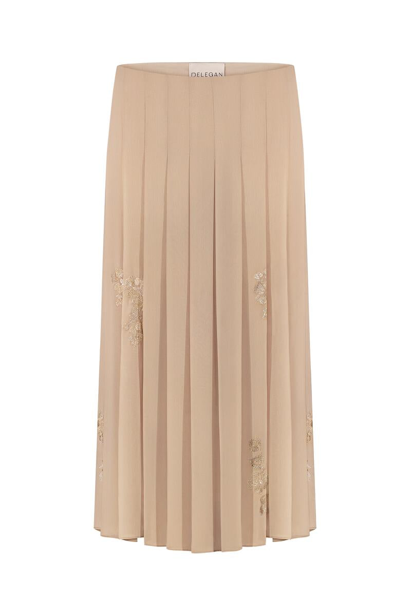 Golden nude pleated midi skirt by DELEGAN displayed on a mannequin front, showcasing its flowing fabric and elegant design.