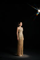 Gold sequined gown by HACCHIC COUTURE featuring sparkling embellishments, fitted silhouette, and elegant design for formal occasions.
