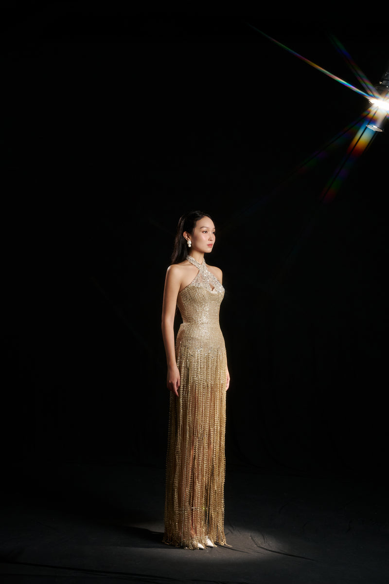 Gold sequined gown by HACCHIC COUTURE featuring sparkling embellishments, fitted silhouette, and elegant design for formal occasions.