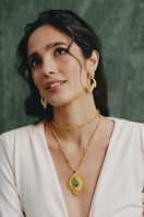 Gold earrings by Jude Benhalim featuring a stylish design, worn by a model showcasing elegant jewelry for women.