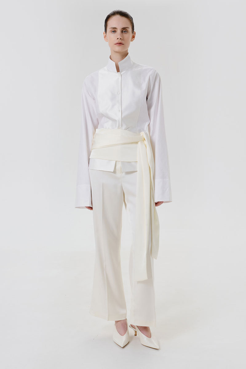 High-resolution image of ivory satin pants with a matching belt from DELEGAN, showcasing a sleek, elegant style and smooth fabric.