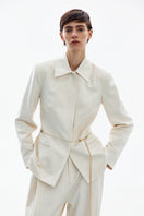 High-resolution image of a white and gold belted jacket by DELEGAN, showcasing the stylish design and luxurious fabric details.