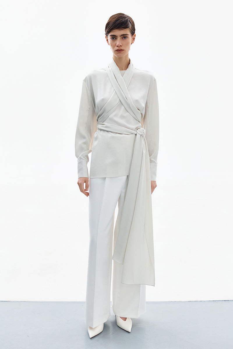 Pearl white wrapped blouse from DELEGAN, high-resolution image showing elegant shirt with button details and smooth fabric.