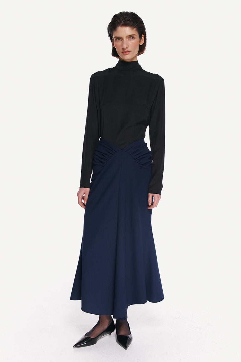 Midnight blue midi skirt by DELEGAN, featuring a flowy fabric and classic length, shown in a high-resolution image.