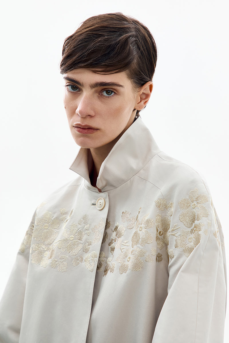 Petal grey beige trench coat by DELEGAN featuring classic design, double-breasted style, and stylish collar detail.