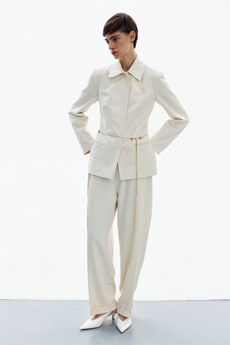 White pants by DELEGAN with a tailored fit, shown in a high-resolution image highlighting the fabric and sleek design.