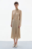Golden nude pleated midi skirt by DELEGAN, shown in high-resolution image with detailed pleats and elegant flow.