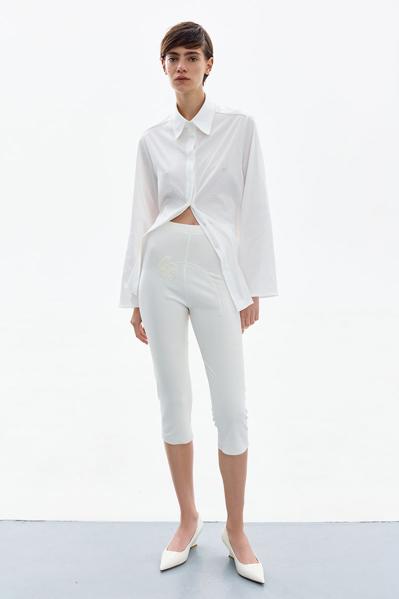 Delegan Blossom White Capri pants with a relaxed fit, showcasing the lightweight fabric and stylish design.