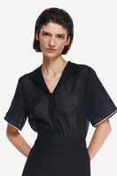 Black DELEGAN shirt with white edging, featuring a classic design and high-resolution fabric detail.