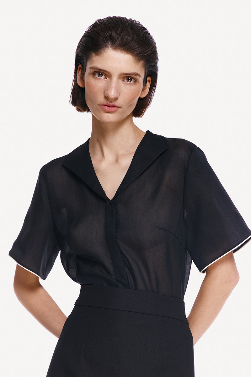 Black DELEGAN shirt with white edging, featuring a classic design and high-resolution fabric detail.