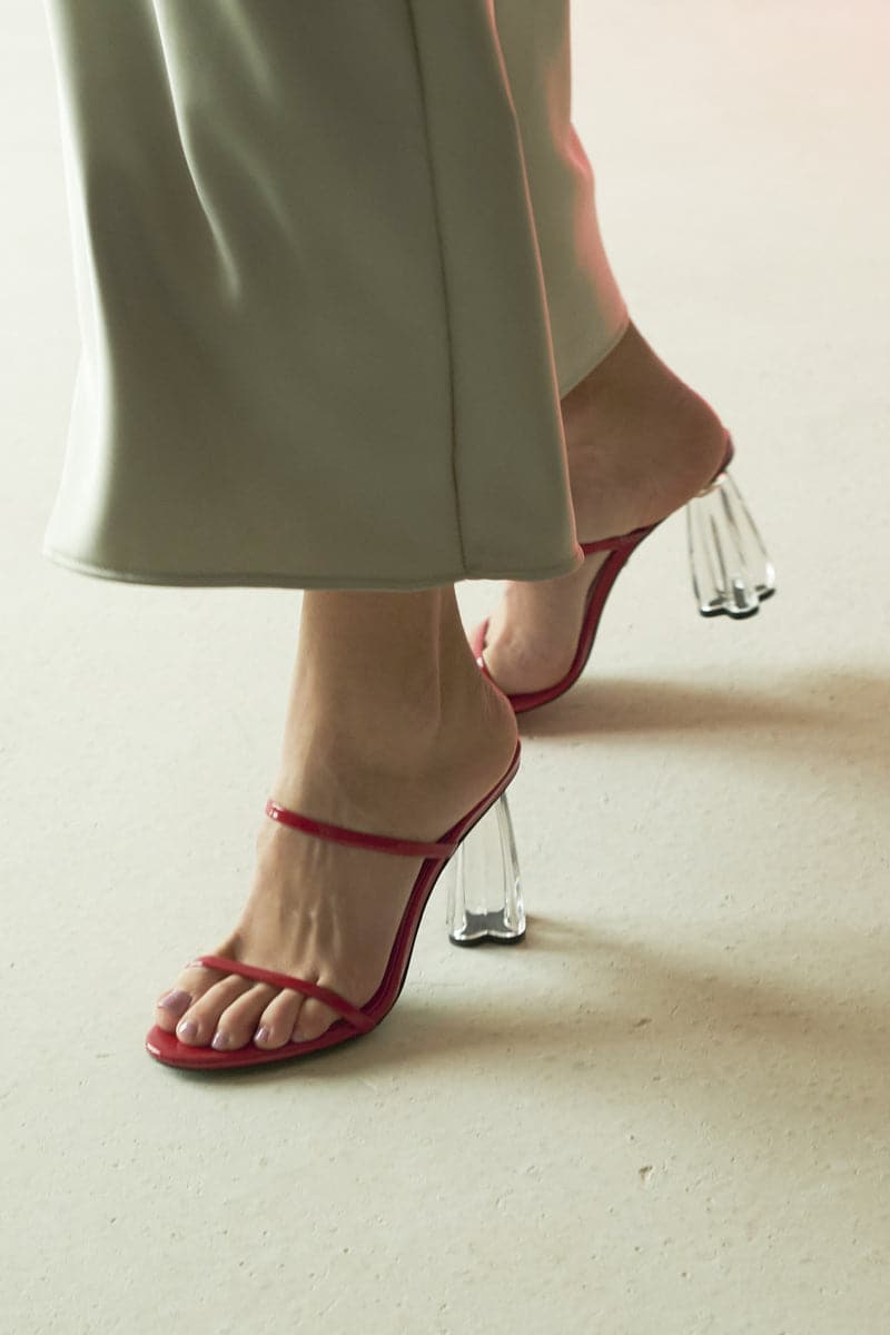 Red Fiorellini glass mule sandals by House of Atana, with glossy patent finish and elegant slip-on design.