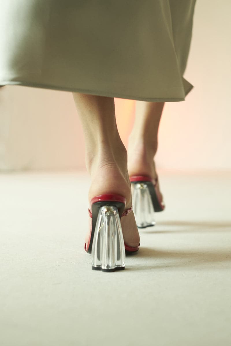 Red glass mules sandals by House of Atana, featuring shiny patent finish and stylish slip-on design.