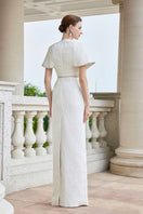 White I.H.F gown with round neck and exaggerated shoulders, shown in a close-up image highlighting the elegant design.