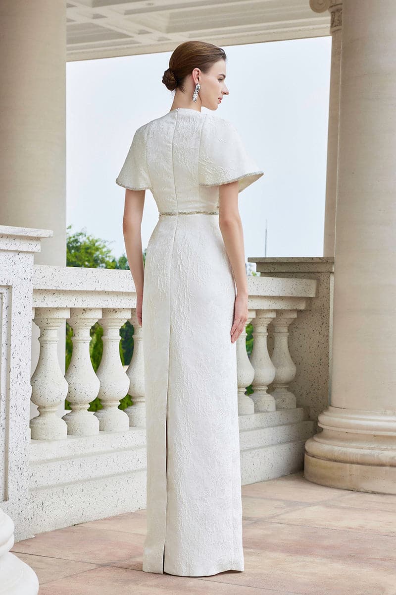 White I.H.F gown with round neck and exaggerated shoulders, shown in a close-up image highlighting the elegant design.