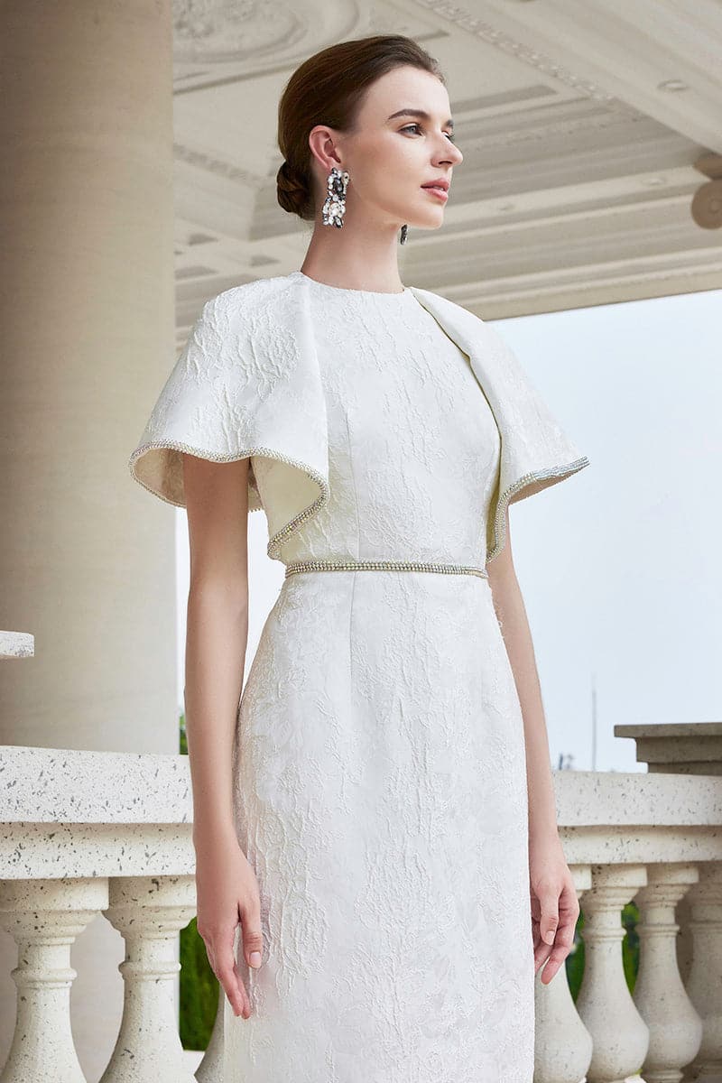 White I.H.F gown with round neckline and exaggerated shoulders, shown in size XXS. Elegant and stylish formal dress.