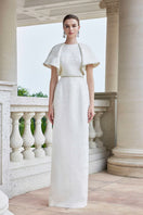 White I.H.F gown with round neck and exaggerated shoulders, showcasing a stylish and elegant design.