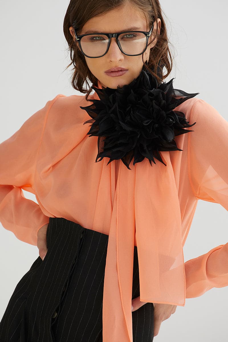 Black flower brooch from BABUKHADIA featuring a detailed floral design, ideal for lapels and accessories.