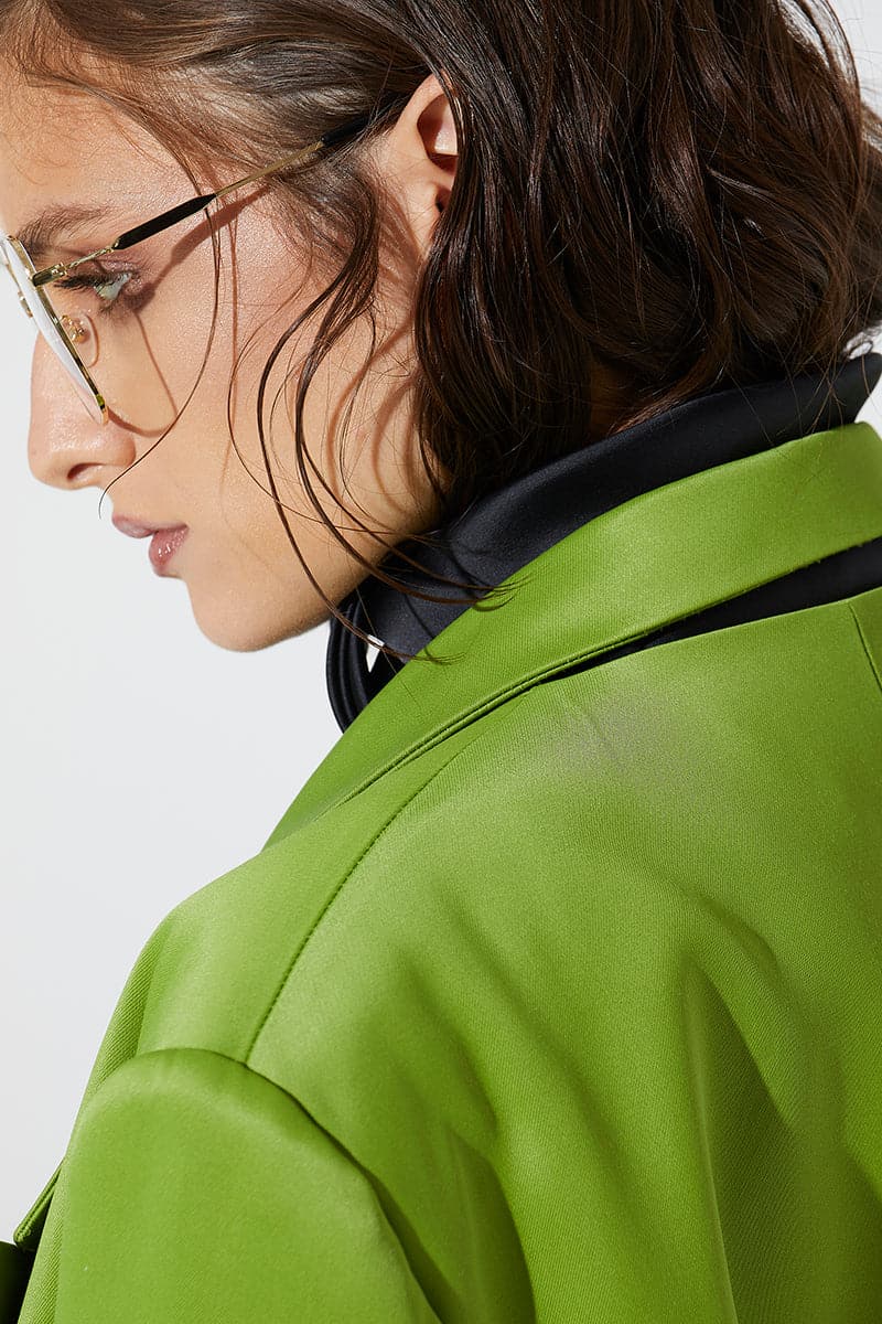 Green wide lapel blazer by Babukhadia, shown on a hanger with detailed fabric texture and tailored fit.