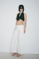 Nué Solange white pants shown on a model, featuring a relaxed fit and stylish design ideal for casual and smart outfits.