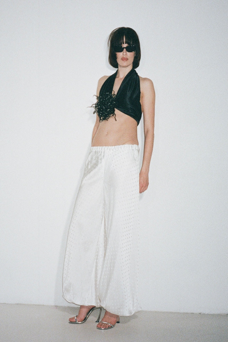 Nué Solange white pants shown on a model, featuring a relaxed fit and stylish design ideal for casual and smart outfits.