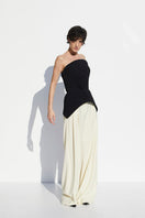 Black strapless peplum top from BABUKHADIA featuring a fitted bodice and flared peplum hem, displayed on a hanger.
