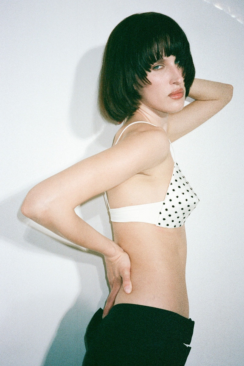 Nué MIMI Bullet Bra in white and black, stylish lingerie with supportive cups and adjustable straps, shown on a model.