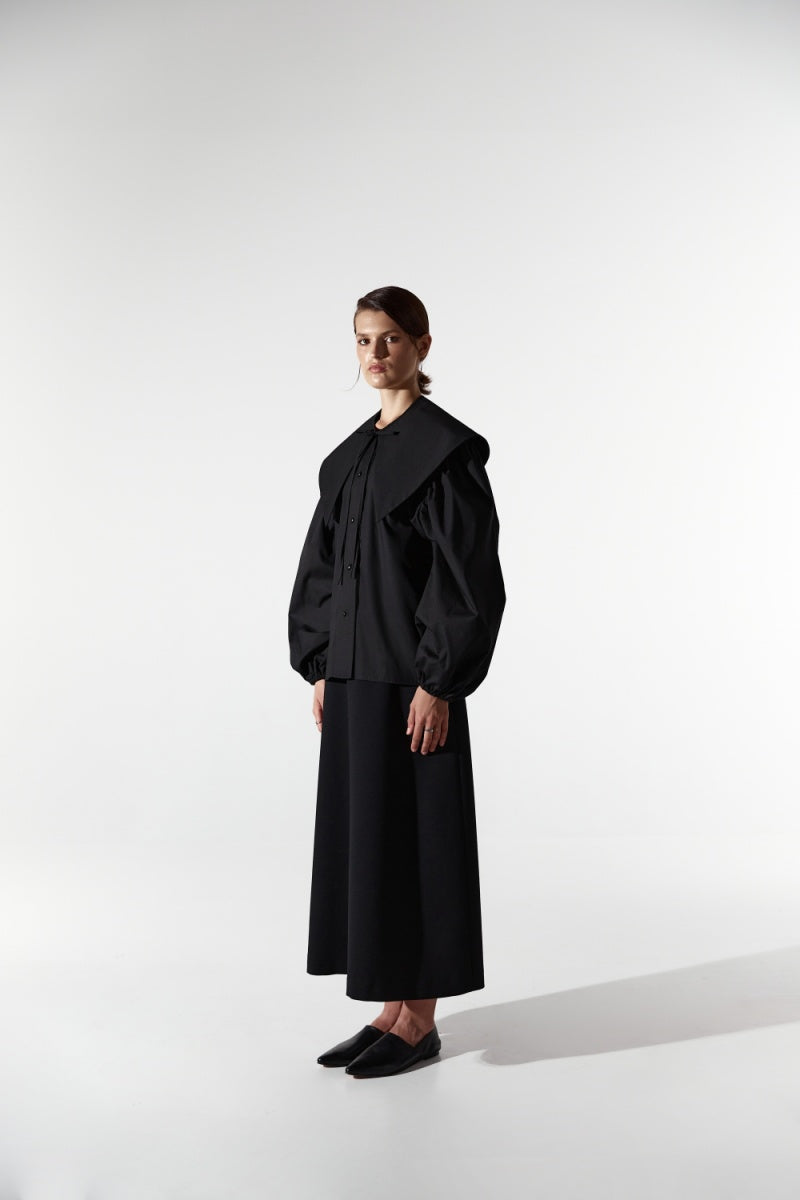 Black collar shirt by DELEGAN, featuring a classic button-up design and tailored fit, displayed on a plain background.