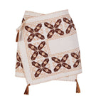 White maxi skirt by JC Pajares with hand embroidery in brown and orange, featuring a cross design and flowing fabric.