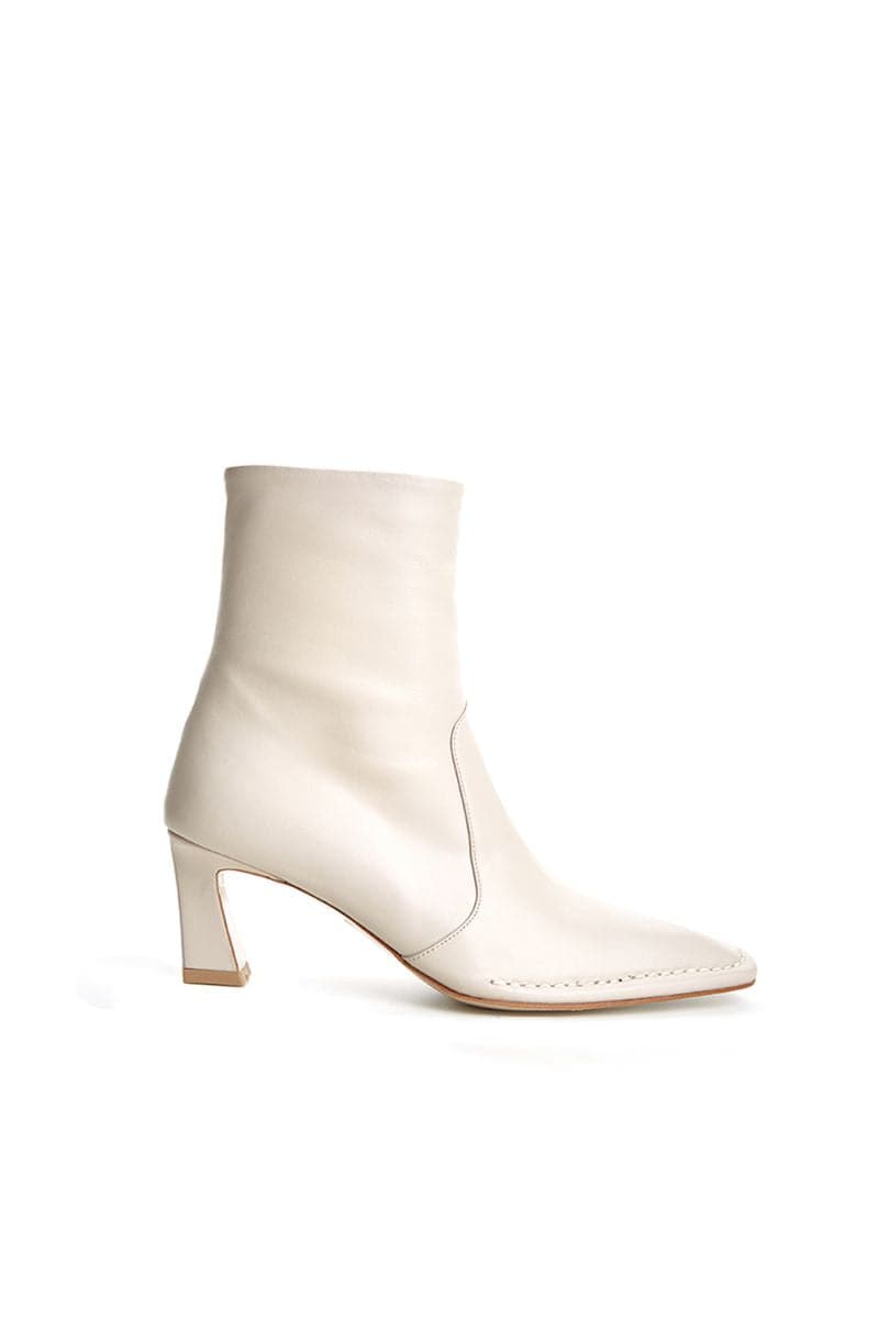 Off-white ankle boots by Je La Connais, featuring a sleek design, low heel, and stylish ankle-length cut.