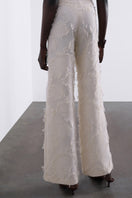 Cream Jora fringe trousers by SÉLONE featuring wide-leg pants with fringe details and a relaxed fit.