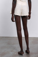 White Jora Fringe Shorts by SÉLONE with fringe detailing, shown laid flat on a neutral background.