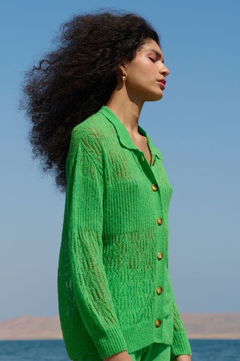 Green La Granni Arañita collared cardigan with long sleeves and button front, styled on a model.