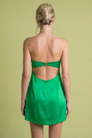 Back view of Laura Escobar Lily mini dress in emerald, showcasing the stylish short dress with flowing fabric and elegant design.