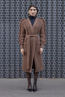 Dark brown hand-knitted coat by Liya, featuring cozy textured knit fabric and a stylish, warm design for winter wear.