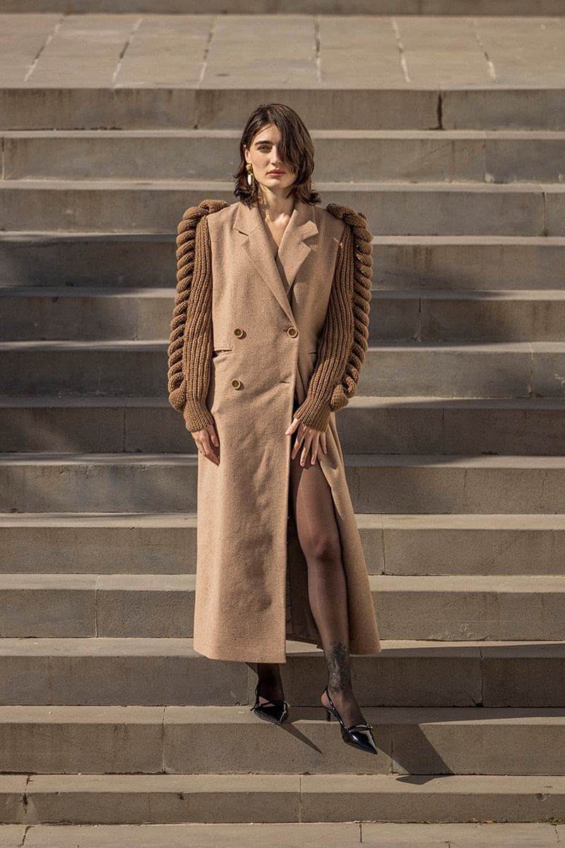 Liya camel double-breasted knitted sleeves coat with a tailored fit and button details, displayed on a hanger.