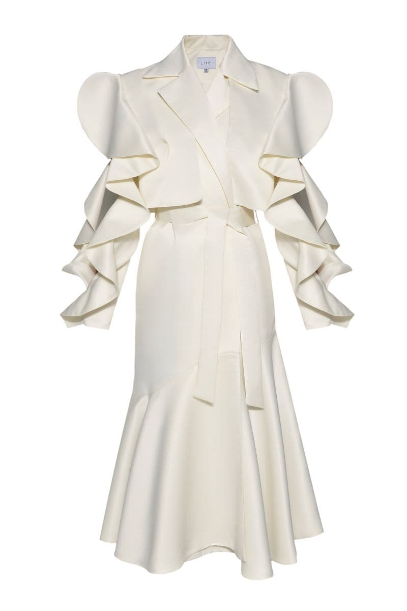 Liya ivory trench coat displayed hanging, featuring classic double-breasted design with belt and tailored fit.
