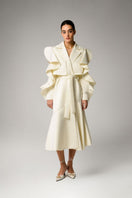Liya ivory trench coat displayed on a hanger, showcasing classic double-breasted design and belted waist in lightweight fabric.